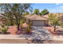 Single-story home with a tile roof, landscaped yard, and a two-car garage at 10387 W Runion Dr, Peoria, AZ 85382