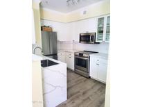 Modern kitchen with stainless steel appliances and white cabinetry at 1701 E Colter St # 223, Phoenix, AZ 85016