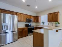 Modern kitchen featuring stainless steel appliances and wood cabinetry at 1828 W Owens Way, Anthem, AZ 85086