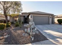 Single-story home with gray exterior, two-car garage, and desert landscaping at 26175 W Firehawk Dr, Buckeye, AZ 85396