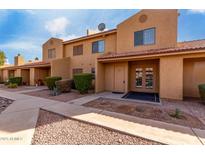 Tan two-story condo building with double door entry and small landscaping at 3511 E Baseline Rd # 1210, Phoenix, AZ 85042