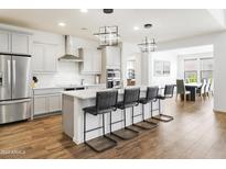 Modern kitchen with gray cabinets, island seating, and open layout at 7180 W Tombstone Trl, Peoria, AZ 85383