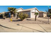 House exterior featuring desert landscaping and a two-car garage at 9916 E Dolphin Cir, Mesa, AZ 85208