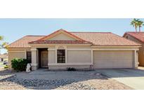 Tan house with a red tile roof, a two-car garage, and desert landscaping at 1237 E Heather Ave, Gilbert, AZ 85234