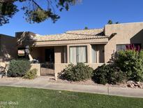 Spanish style home with tiled roof, gated entrance, and mature landscaping at 14300 W Bell Rd # 207, Surprise, AZ 85374