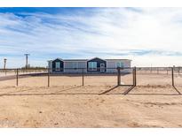 Single-story home with gray siding and a fenced yard at 36711 W Harrison St, Tonopah, AZ 85354