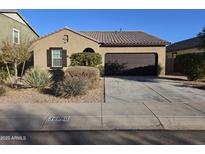 Single-story home with a two-car garage and landscaped front yard at 36850 W Nola Way, Maricopa, AZ 85138