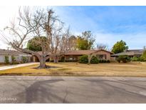 Ranch style home with mature landscaping and a large front yard at 3809 E Highland Ave, Phoenix, AZ 85018