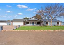 Ranch style home with solar panels, landscaped lawn, and two-car garage at 1120 E Kael Cir, Mesa, AZ 85203