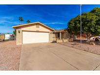 Brick ranch house with a large tree, driveway, and landscaped yard at 1724 W 15Th Ave, Apache Junction, AZ 85120