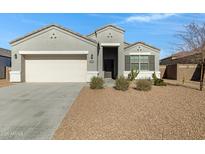 One-story house with gray exterior, two-car garage, and desert landscaping at 29402 W Mitchell Ave, Buckeye, AZ 85396