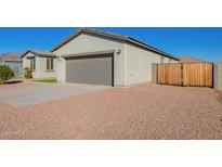 House exterior with gray walls, two-car garage, and a landscaped front yard at 34909 N Palm Dr, San Tan Valley, AZ 85140