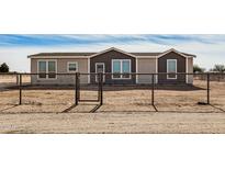 Tan and dark brown single-story house with a gated fence at 36747 W Harrison St, Tonopah, AZ 85354