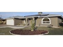 House exterior featuring a brick facade, landscaped yard, and a two-car garage at 4054 E Clovis Cir, Mesa, AZ 85206