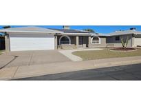Charming brick home featuring a two-car garage, solar panels, arched windows and desert landscaping at 4054 E Clovis Cir, Mesa, AZ 85206