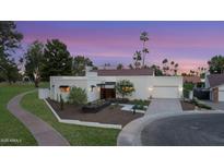Stunning home boasts a clean, modern design with beautiful landscaping and a spacious driveway at 8255 E Morgan Trl, Scottsdale, AZ 85258