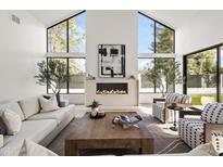 Bright living room features large windows, modern fireplace, and stylish decor at 8255 E Morgan Trl, Scottsdale, AZ 85258