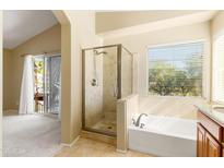 Main bathroom featuring tile floors, a glass shower, and a soaking tub with a window view at 11825 S 46Th St, Phoenix, AZ 85044