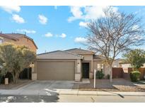 Beige house with a two-car garage and landscaping at 1381 W Birch Rd, Queen Creek, AZ 85140