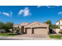 Tan two-story house with three-car garage and manicured lawn at 4400 S Oleander Dr, Chandler, AZ 85248