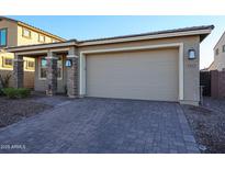 Tan house with a two car garage and brick columns at 5523 W Chuck Box Rd, Laveen, AZ 85339