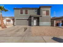 Two-story house with gray siding, attached garage, and landscaping at 11514 W Charter Oak Rd, El Mirage, AZ 85335