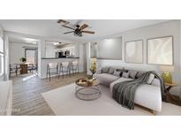 Bright living room featuring neutral tones, open layout, ceiling fan, and modern decor accents at 11782 W Columbine Dr, El Mirage, AZ 85335