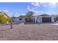 White single story home with a dark brown garage door and a rock front yard at 1703 E Laguna Dr, Tempe, AZ 85282