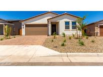 Charming single-story home with a desert landscape and a brown two car garage at 18556 E Dario Rd, Gold Canyon, AZ 85118