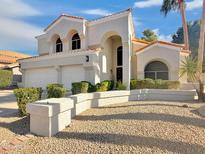 Charming two-story home featuring a three-car garage, desert landscaping, and an inviting arched entrance at 19531 N 69Th Ave, Glendale, AZ 85308