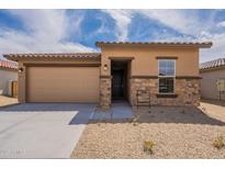 Charming single-story home featuring a two-car garage and a stone-accented facade with a well-maintained front yard at 24153 W Hilton Ave, Buckeye, AZ 85326
