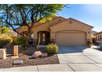 Tan house with a two-car garage and landscaping at 26907 N 51St Dr, Phoenix, AZ 85083