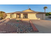 Single-story home with a rock garden, solar panels, and a two-car garage at 4301 W Dahlia Dr, Glendale, AZ 85304