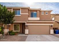 Two-story house with tan exterior, two-car garage, and landscaping at 4723 W Gelding Dr, Glendale, AZ 85306