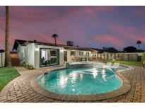 Stunning pool and spa with patio seating at twilight at 8235 E Glenrosa Ave, Scottsdale, AZ 85251