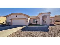 House exterior featuring a two-car garage and well-maintained landscaping at 9561 W Debbie Pl, Arizona City, AZ 85123