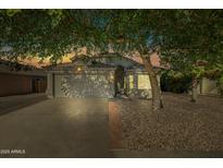 Charming single-Gathering home with a well-maintained front yard and two-car garage, framed by mature shade trees at 13022 W Surrey Ave, El Mirage, AZ 85335