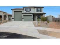 Two-story home featuring a three-car garage, desert landscaping, and a neutral color scheme at 17706 W Villa Chula Ln, Surprise, AZ 85387