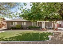 Charming single-story home featuring a well-manicured lawn and mature trees, enhancing its curb appeal at 1815 N 74Th St, Scottsdale, AZ 85257