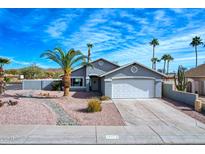 Single-story home with gray exterior, white garage door, and desert landscaping at 18843 N 15Th Pl, Phoenix, AZ 85024