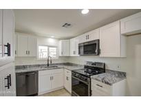 Modern kitchen featuring white cabinets, granite counters, and stainless steel appliances at 2657 W Superstition Blvd, Apache Junction, AZ 85120