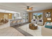 Open living room features a kitchen with breakfast bar and access to a patio at 9814 W Cedar Dr, Sun City, AZ 85351