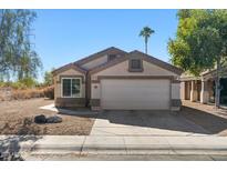Single-story home with a two-car garage and desert landscaping at 11227 W Phillip Jacob Dr, Surprise, AZ 85378