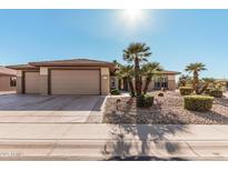 Tan two-car garage home with desert landscaping at 16983 W Desert Blossom Way, Surprise, AZ 85387