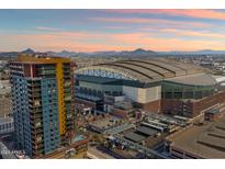 Stunning aerial view showcases a high-rise building near a stadium, with mountains in the distance under a vibrant sky at 310 S 4Th St # 908, Phoenix, AZ 85004