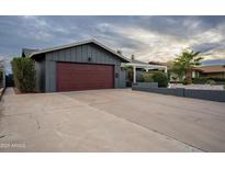 Ranch style home with a red garage door and landscaped yard at 3515 W St Moritz Ln, Phoenix, AZ 85053