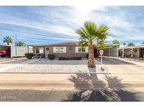 Tan single-story home with carport and palm tree in front at 5241 E Lindstrom Ln, Mesa, AZ 85215