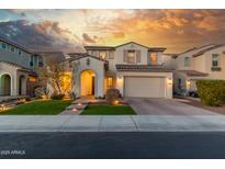 Two-story house with arched entry, landscaping, and a three-car garage at 7438 W Jasmine Trl, Peoria, AZ 85383