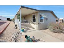Tan mobile home exterior with covered porch, stairs, and landscaping at 11596 W Sierra Dawn -- # 132, Surprise, AZ 85378
