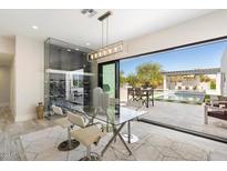 Bright dining area with glass table, modern chairs, and views to the backyard pool at 13613 N 76Th St, Scottsdale, AZ 85260